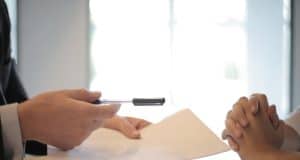 Cómo conseguir préstamos privados Crop businessman giving contract to woman to sign
