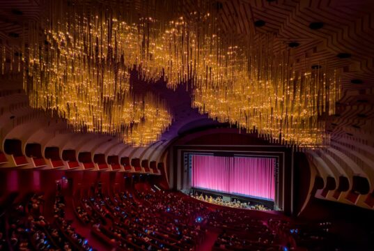 Las mejores obras de teatro de 2024 A large auditorium with a stage and a large screen