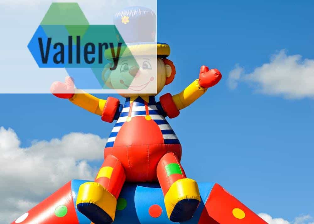 Photo by Wolfgang Weiser A vibrant inflatable clown at an outdoor carnival under a bright blue sky, symbolizing fun and joy.