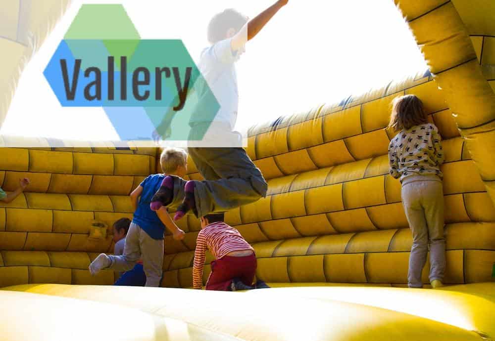 Kids enjoying a fun time bouncing in a vibrant inflatable castle outdoors.
