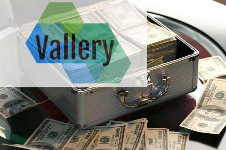 Open briefcase filled with stacks of hundred dollar bills on a glass table, representing wealth.